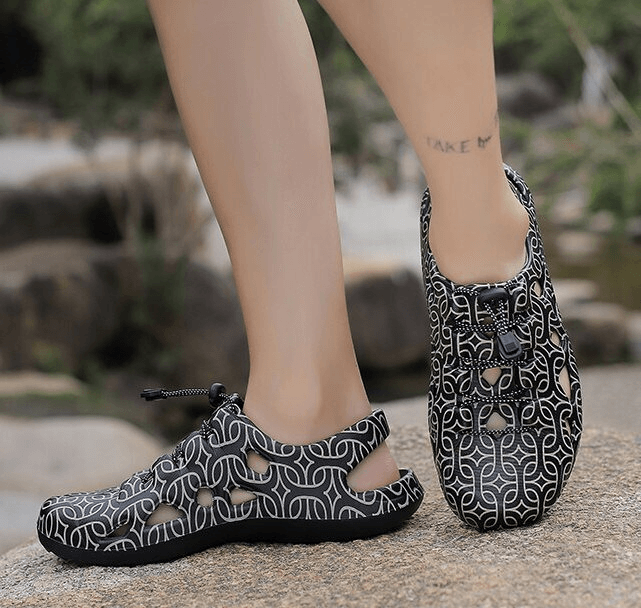 Person wearing stylish men's lightweight quick dry clogs with unique pattern, showcasing comfortable casual footwear for outdoor activities.